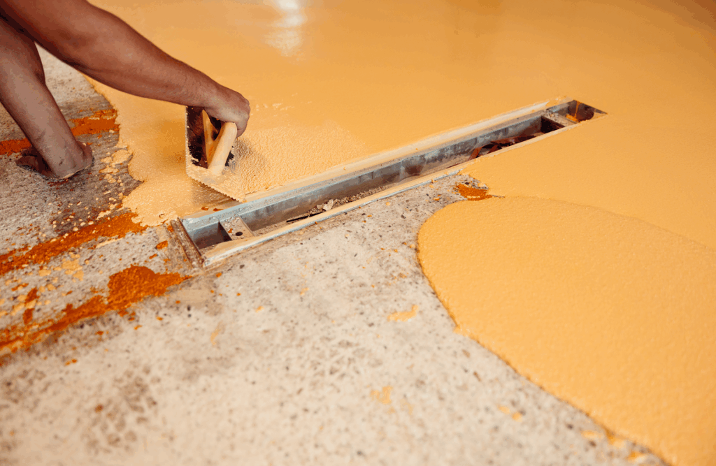 Pinturas Flores, Impermeaibilizaciones de alta calidad en La Jana. Un trabajador impermeabilizando el alrededor de un agujero con resina naranja.
