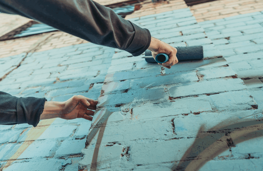 Pinturas Flores, Revestidores de fachadas cualificados en Càlig. Pintor pintando una fachada de azul claro.
