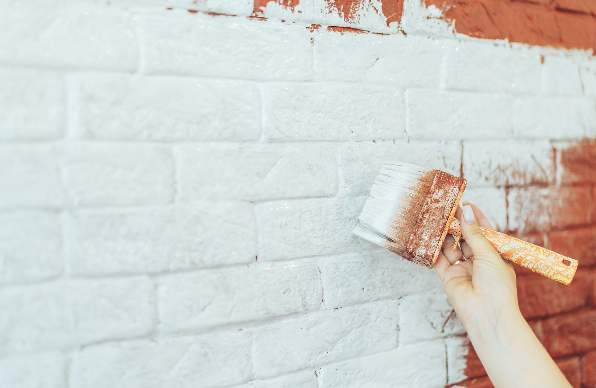 Pinturas Flores, Revestidores de fachadas cualificados en La Jana. Pintor pintando una pared de ladrillos de blanco.