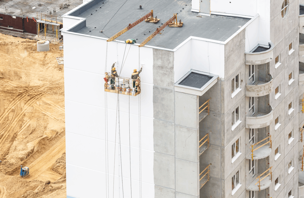 Pinturas Flores, Revestidores de fachadas cualificados en Sant Jordi. Un par de pintores pintando la fachada de un edificio recién construido de blanco.