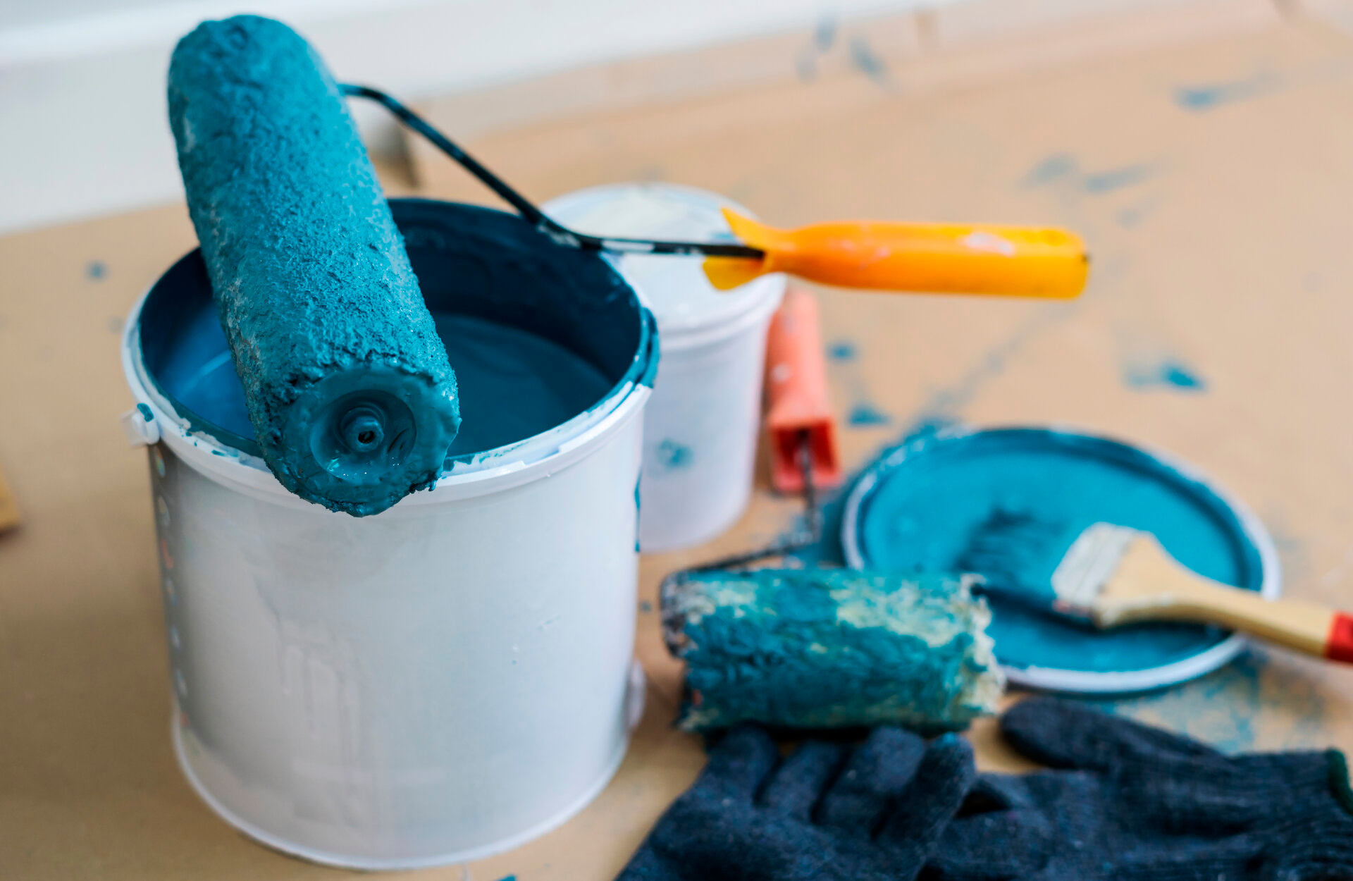 Pinturas Flores, servicios de pintura profesionales en Peñíscola. Cubo y rodillo con pintura azul.