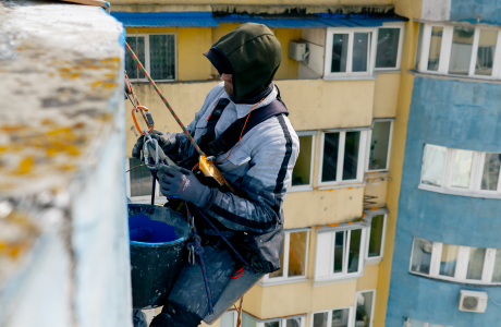 Pinturas Flores, Revestidores de fachadas cualificados en Vinaròs. Pintor aguantando un cubo de pintura azul.