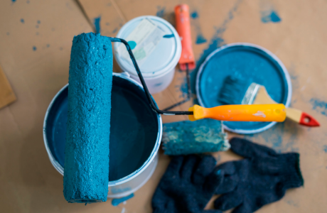 Pinturas Flores, servicios de pintura profesionales en Traiguera. Cubo y rodillo con pintura azul desde arriba.